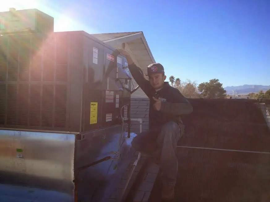 HVAC technician performing AC Tune-Up on a rooftop unit in Gig Harbor